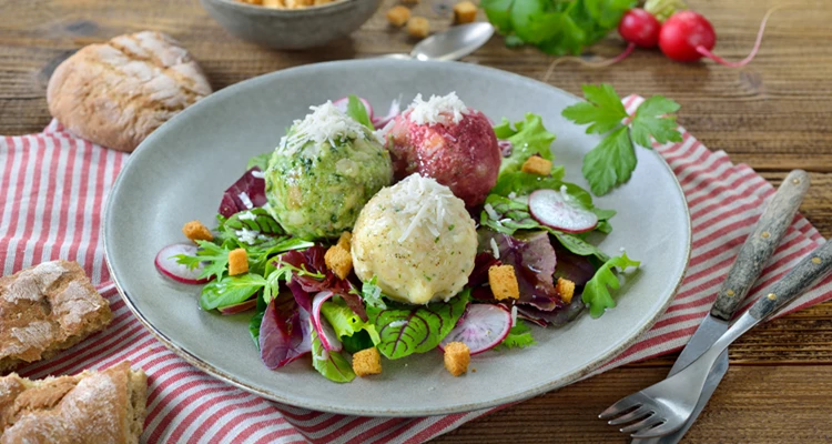 Dreierlei Knödel auf buntem Blattsalat mit Radieschen und Käse